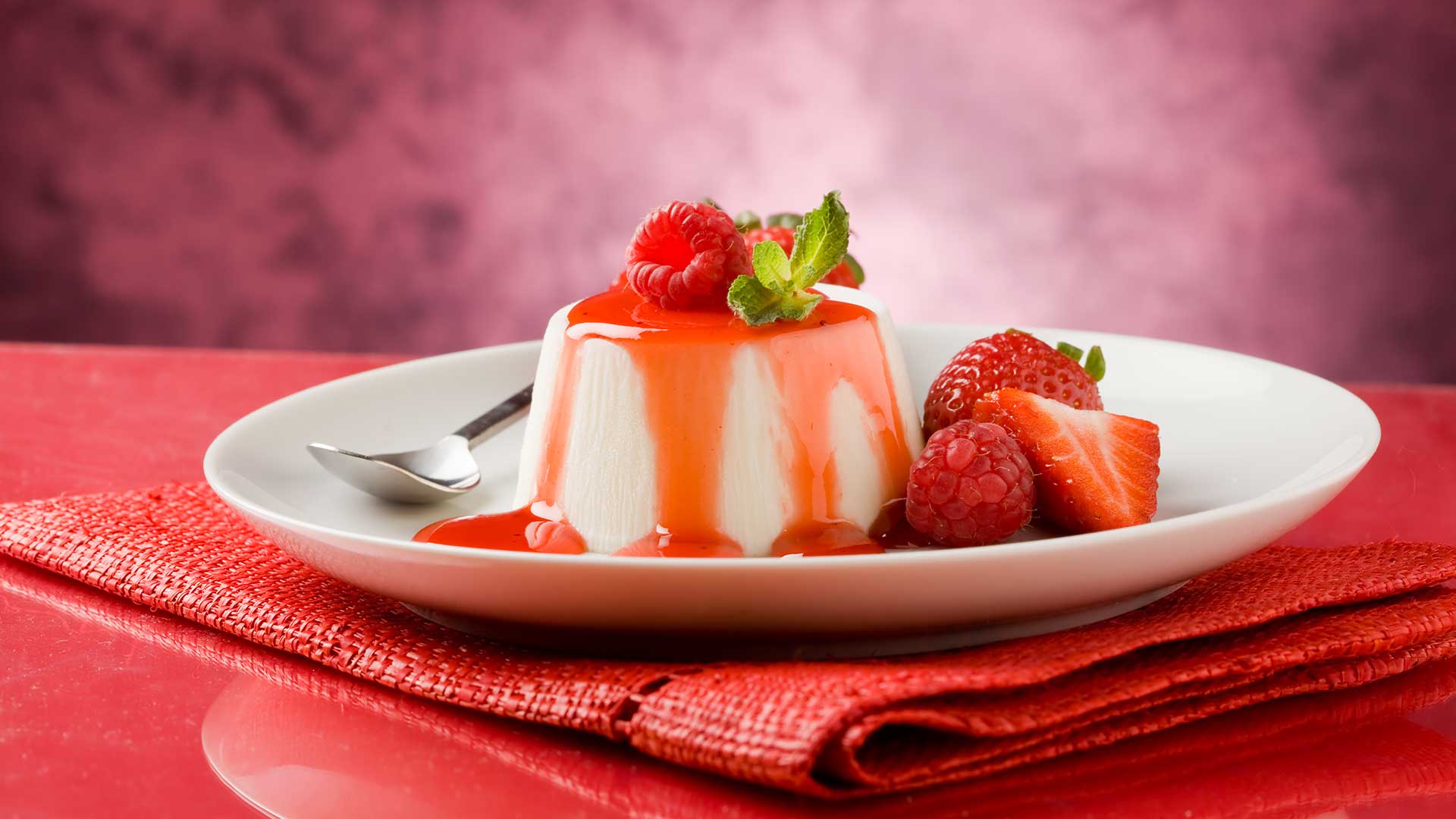 Panacotta mit Erdbeersoße und Erdbeeren garniert